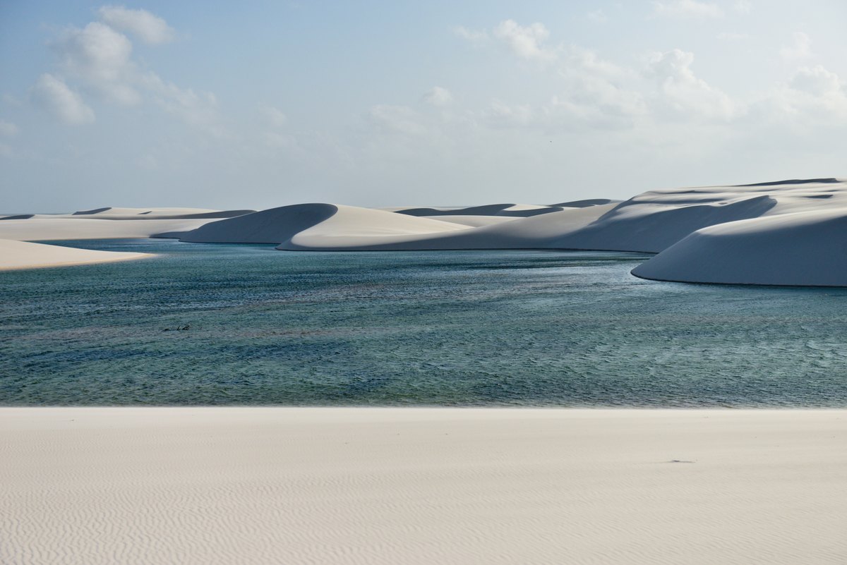 Sweeping white dunes with bright blue lagoons filling the hollows between them.