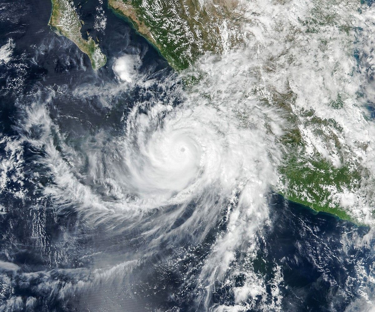 A satellite image shows a swirling hurricane with a clearly defined eye surrounded by bands of cloud.