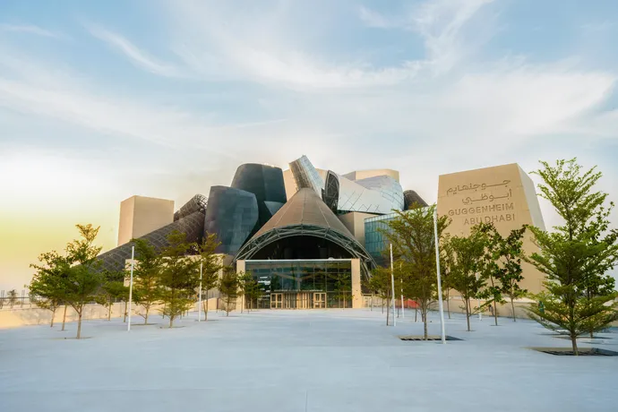 An architectural rendering shows Guggenheim Abu Dhabi's sculptural cone forms arranged around open spaces.
