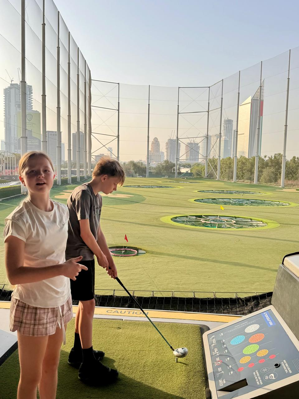 Aimee and her brother at a driving range in Dubai