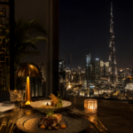A premium Dubai restaurant table with elegant plates, seafood, pasta, grilled dishes, desserts and warm golden dining room lighting.