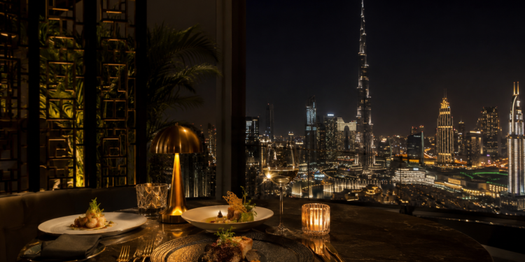 A premium Dubai restaurant table with elegant plates, seafood, pasta, grilled dishes, desserts and warm golden dining room lighting.