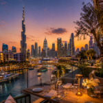 A premium Dubai restaurant table with elegant dishes, glassware, warm lighting and skyline views in the background.