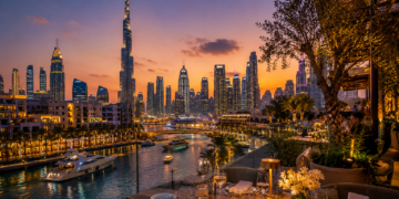 A premium Dubai restaurant table with elegant dishes, glassware, warm lighting and skyline views in the background.