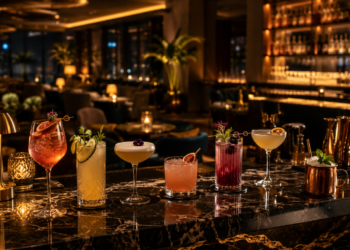 A premium Dubai bar interior with elegant mocktails and cocktails, warm lighting, dark marble, gold accents and a stylish lounge atmosphere.