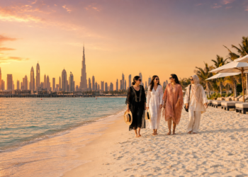 Women enjoying a Dubai beach at sunset with the Burj Khalifa skyline