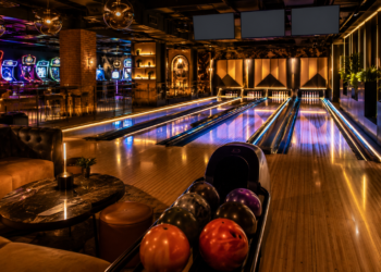 A premium bowling alley scene with glowing lanes, bowling balls, pins, arcade lights and a stylish indoor entertainment atmosphere in Dubai.