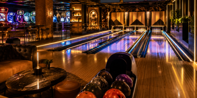 A premium bowling alley scene with glowing lanes, bowling balls, pins, arcade lights and a stylish indoor entertainment atmosphere in Dubai.