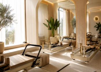 A premium Dubai Pilates studio with reformer machines, soft natural lighting, neutral interiors and calm wellness details.