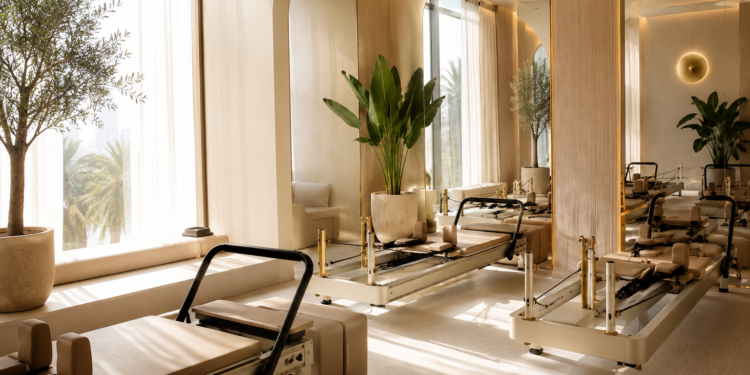 A premium Dubai Pilates studio with reformer machines, soft natural lighting, neutral interiors and calm wellness details.