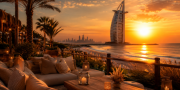 A premium Dubai sunset scene with golden sky, skyline views, beach seating and warm evening lighting.
